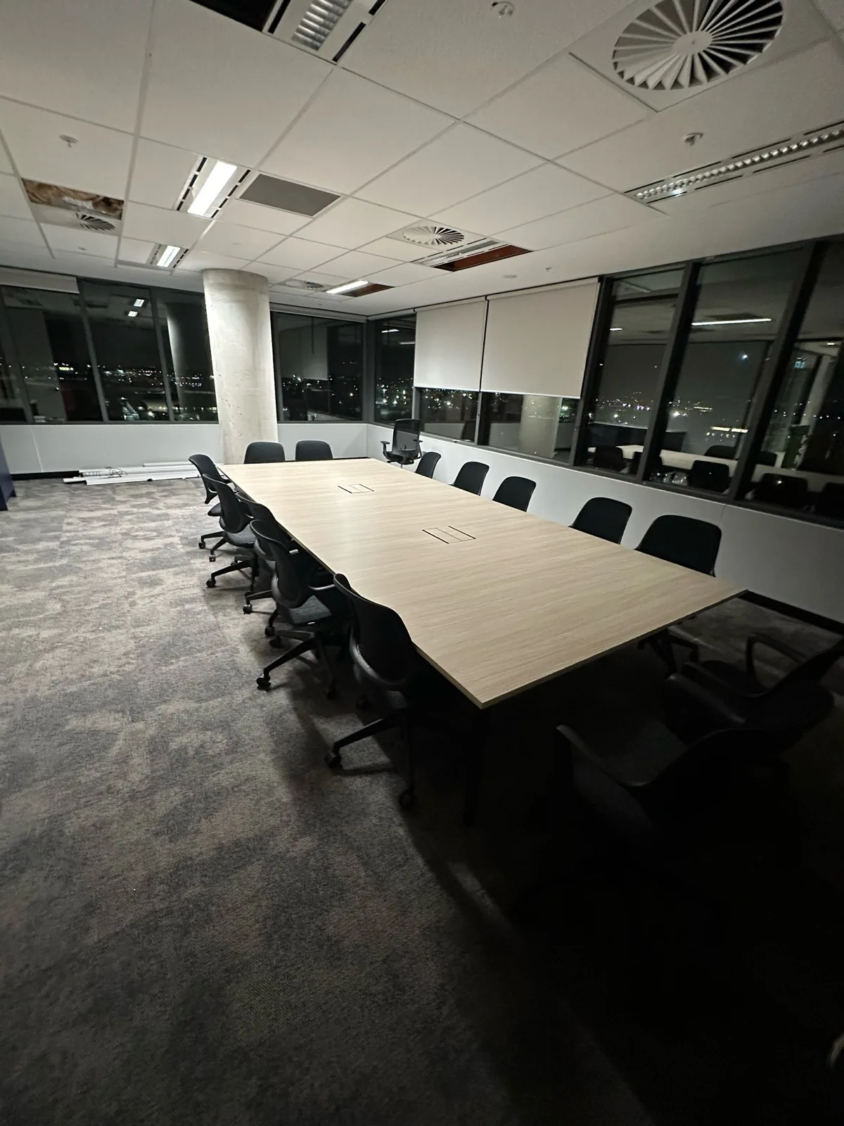 Long boardroom table and chairs installed in an office