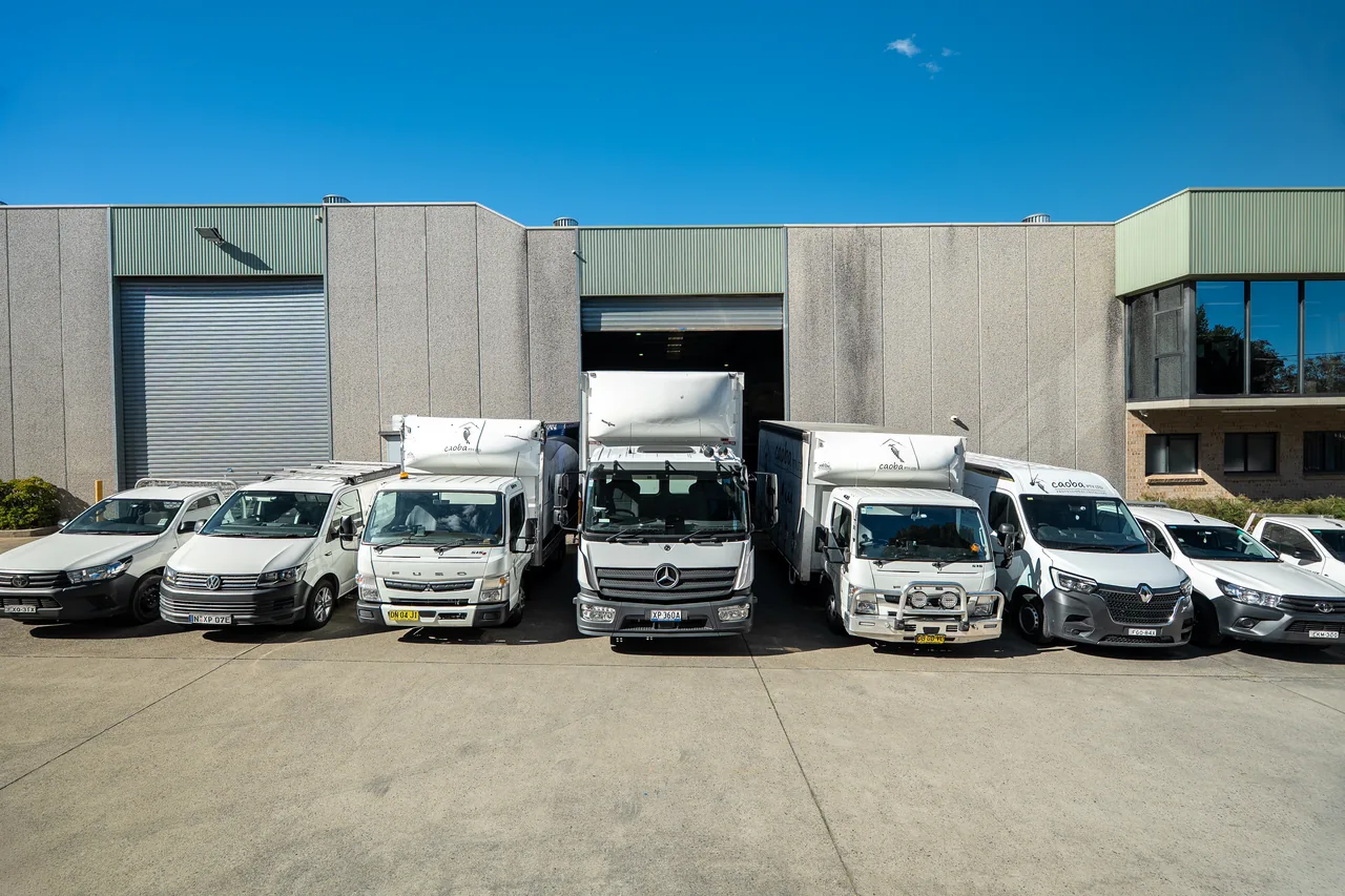 Caoba vans and trucks parked in front of the warehouse