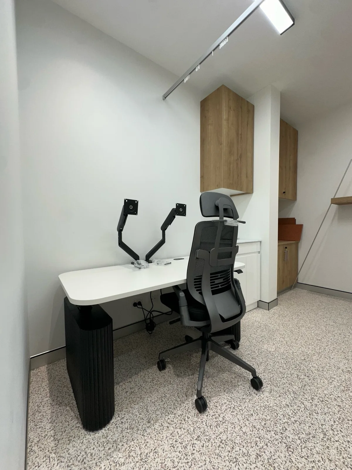 Consulting room desk with ergonomic chair and monitor arms