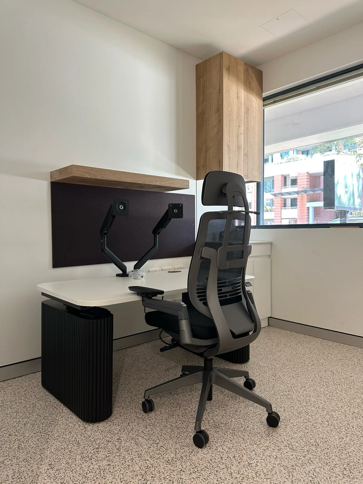 Consulting room with sit-stand desk, monitor arms and timber shelf