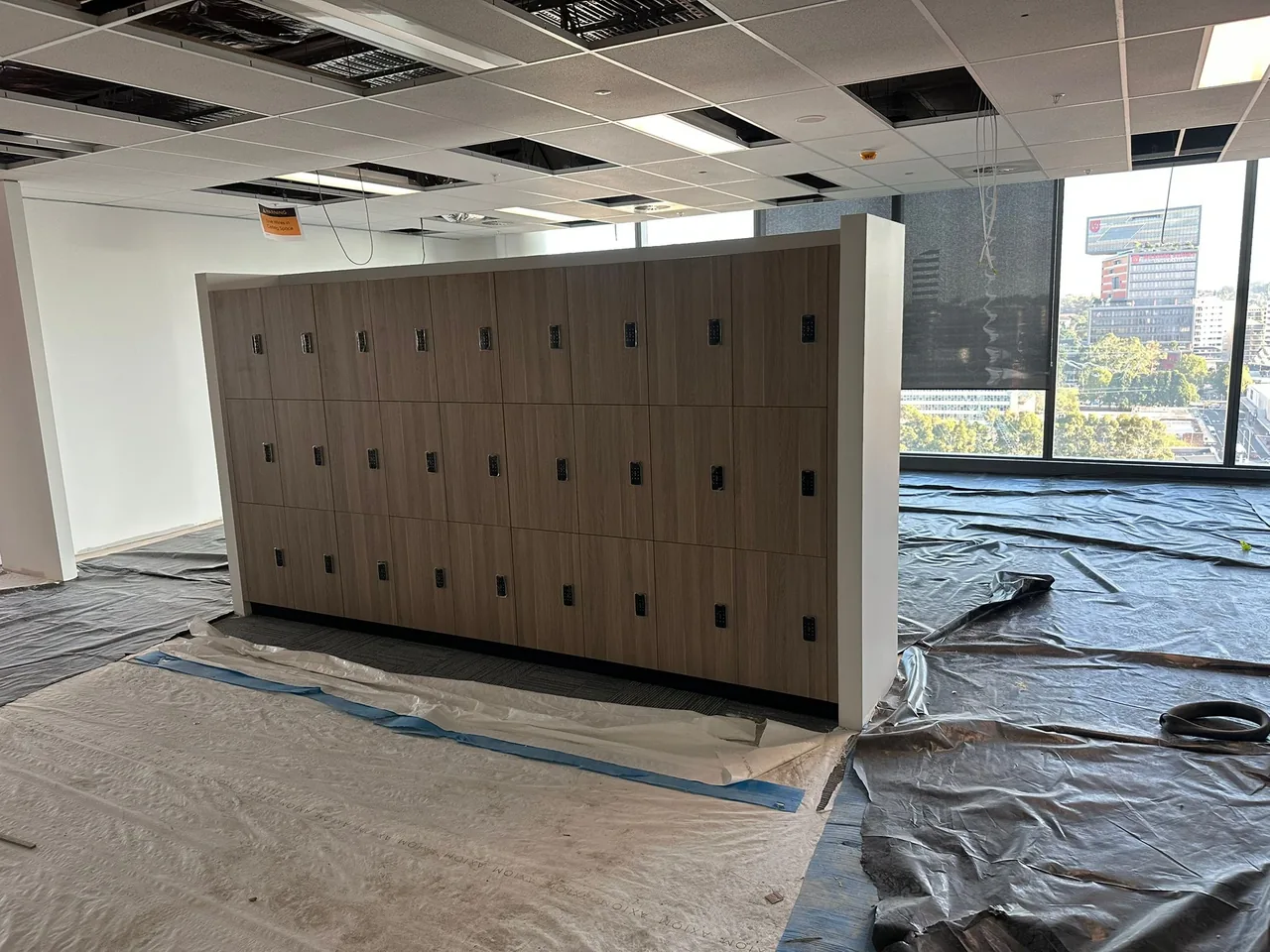 Locker bank installed with floor protection still down on an office fit-out