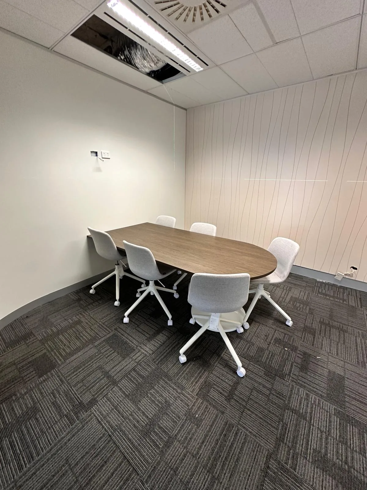 Meeting room with an oval table and white chairs