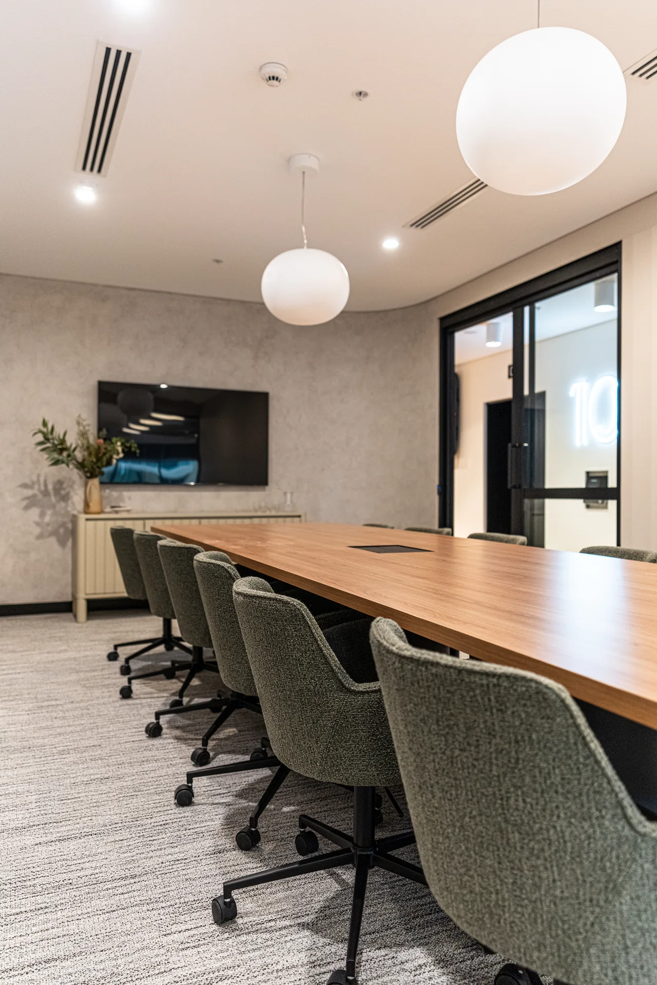 Meeting room with a long timber table and upholstered chairs