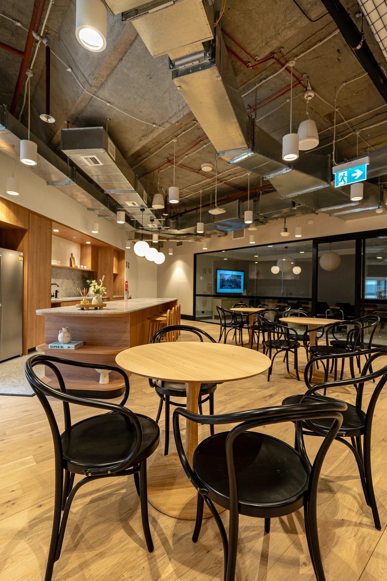 Round timber tables and bentwood chairs in an office breakout space