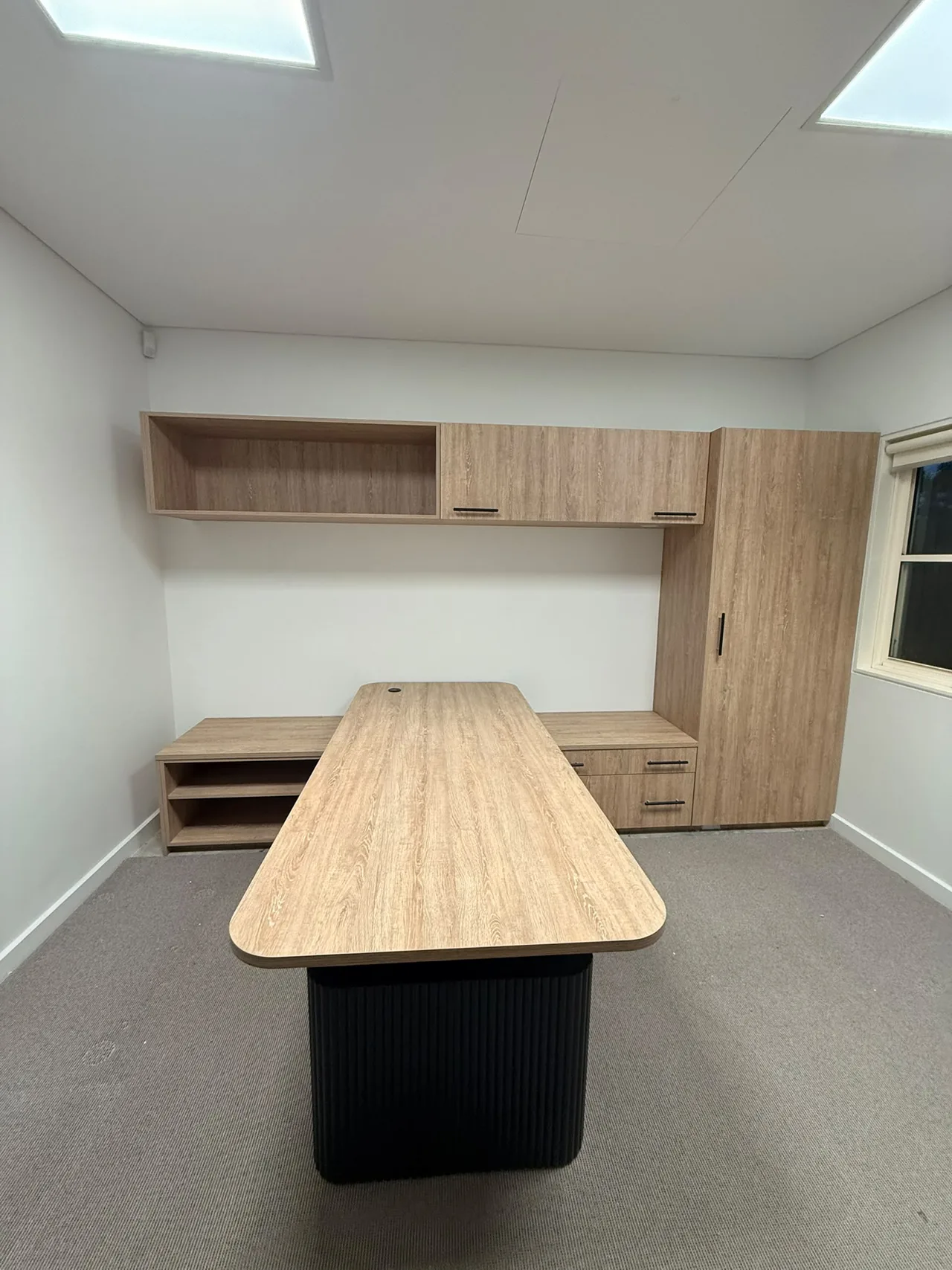 Office desk with matching overhead cabinets and wardrobe joinery