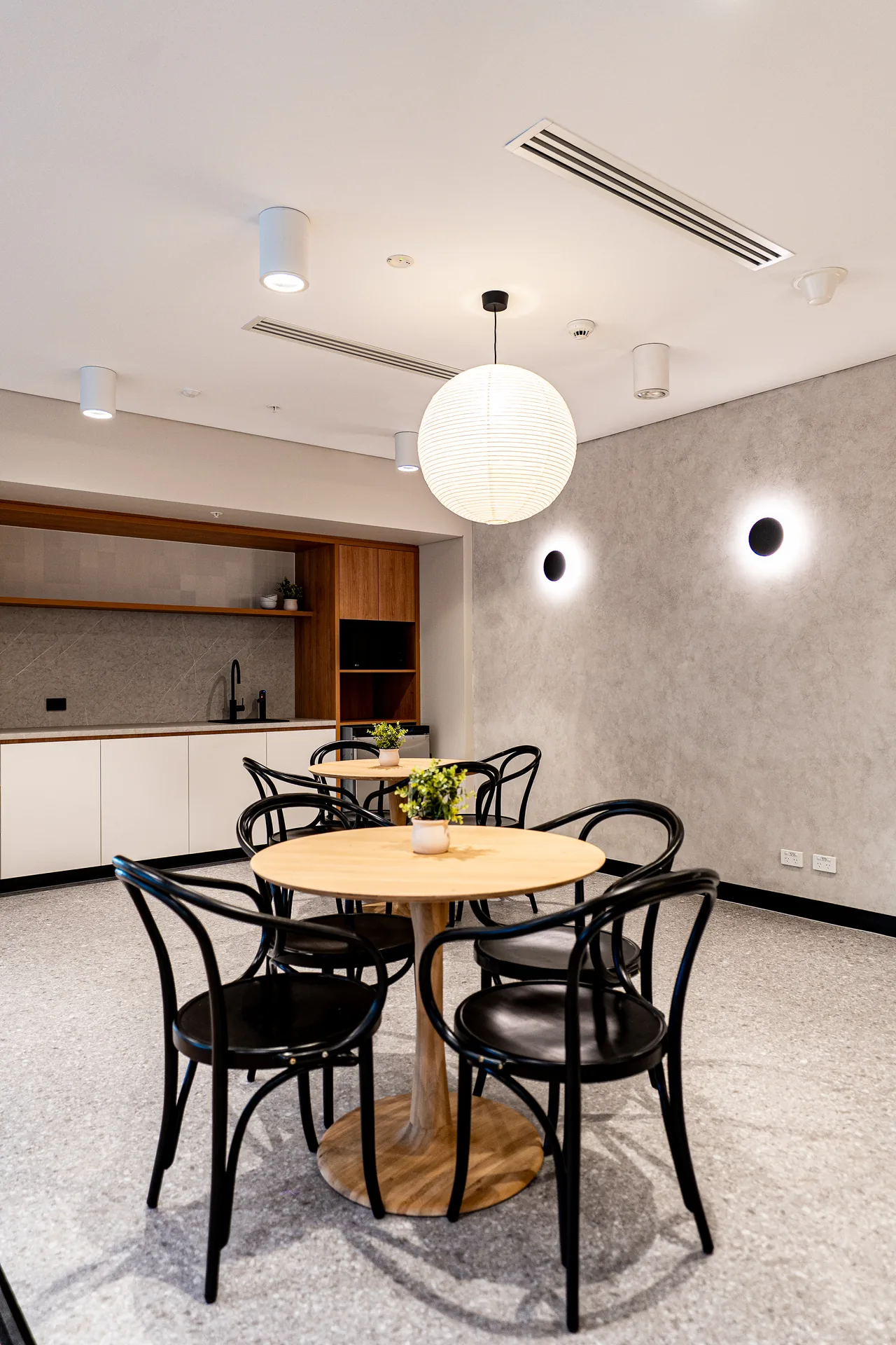 Office kitchenette with a round timber table and bentwood chairs