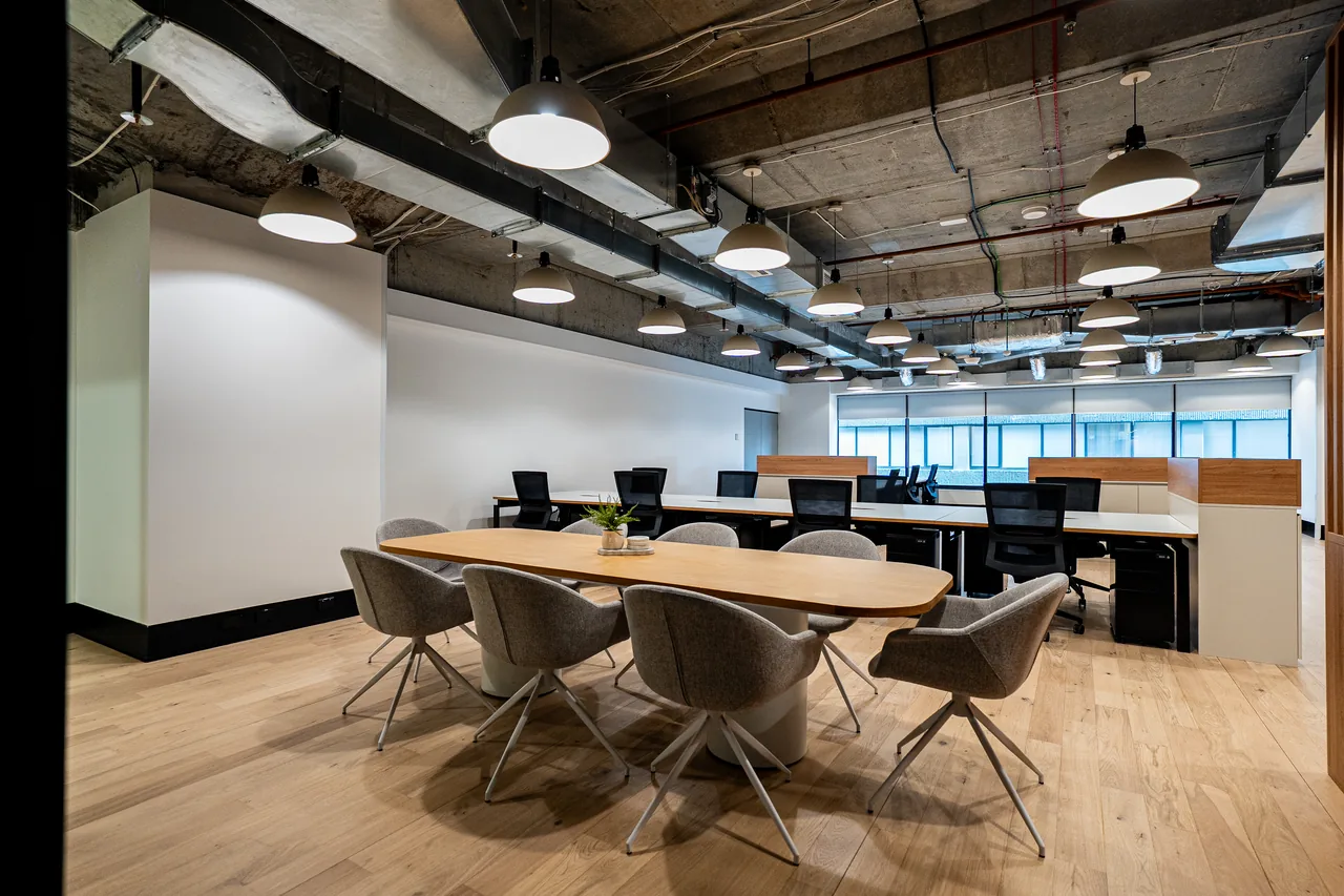 Oval meeting table and swivel chairs set within an open-plan office