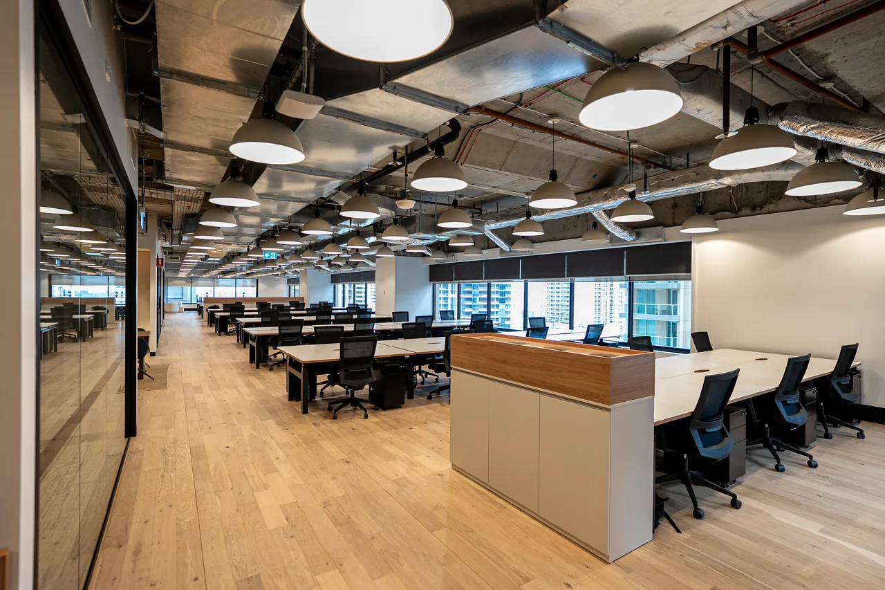 Open-plan office floor with rows of installed workstations and timber-topped storage in Sydney CBD