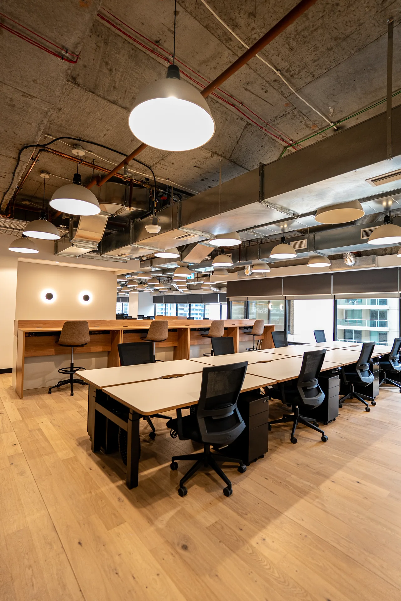 Workstations and timber storage units along the windows of an open-plan office